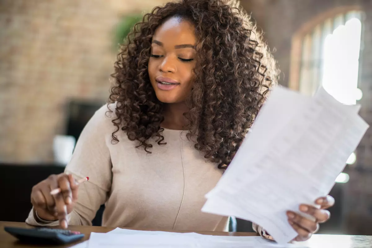 Financiamento ou consórcio: qual a melhor opção para casa própria? Pessoa conferindo todos os detalhes sobre financiamento ou consórcio para escolher melhor opção.
