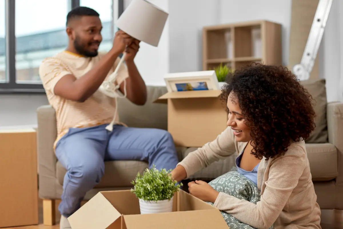 Mudança de casa: confira um guia para se preparar! Casal empacotando itens na mudança de casa.