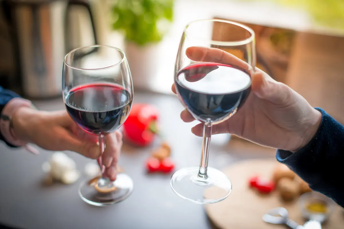 Adega para sala: saiba como criar o espaço ideal no seu lar! Amigos brindando com taça de vinho.