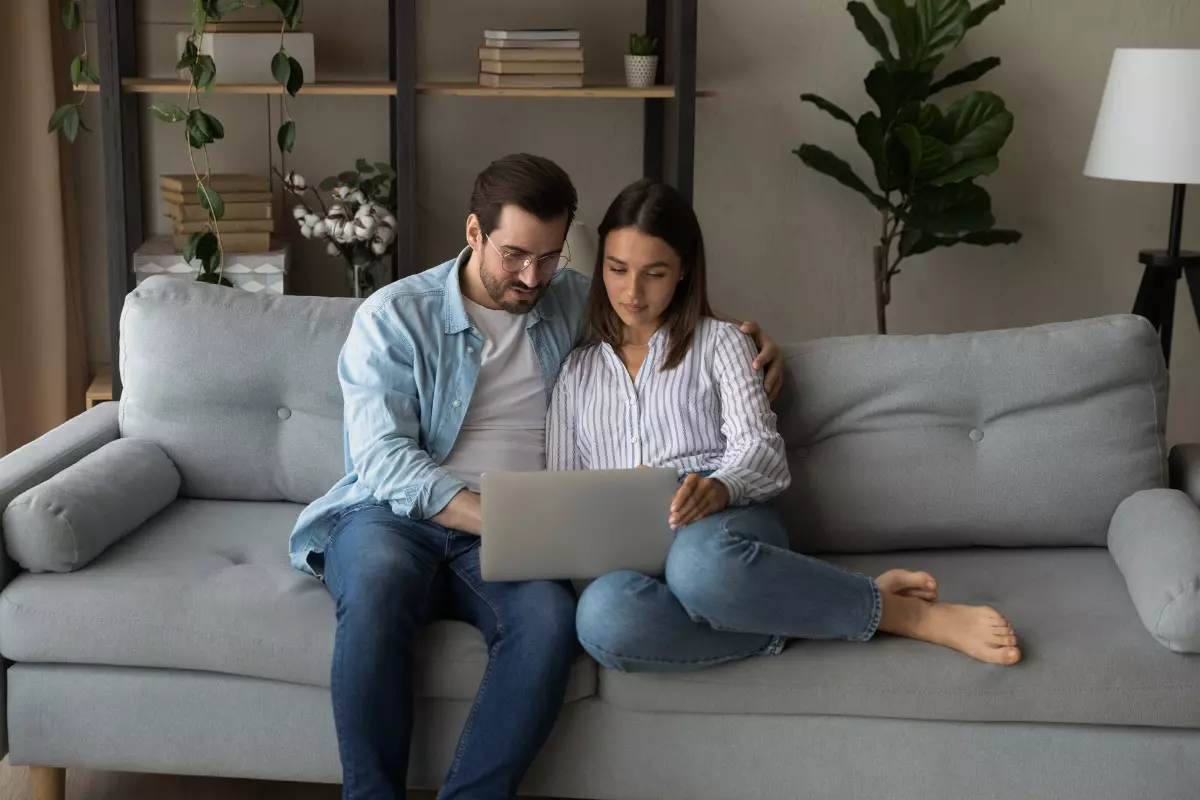 Casal criando uma lista de casamento com um computador.