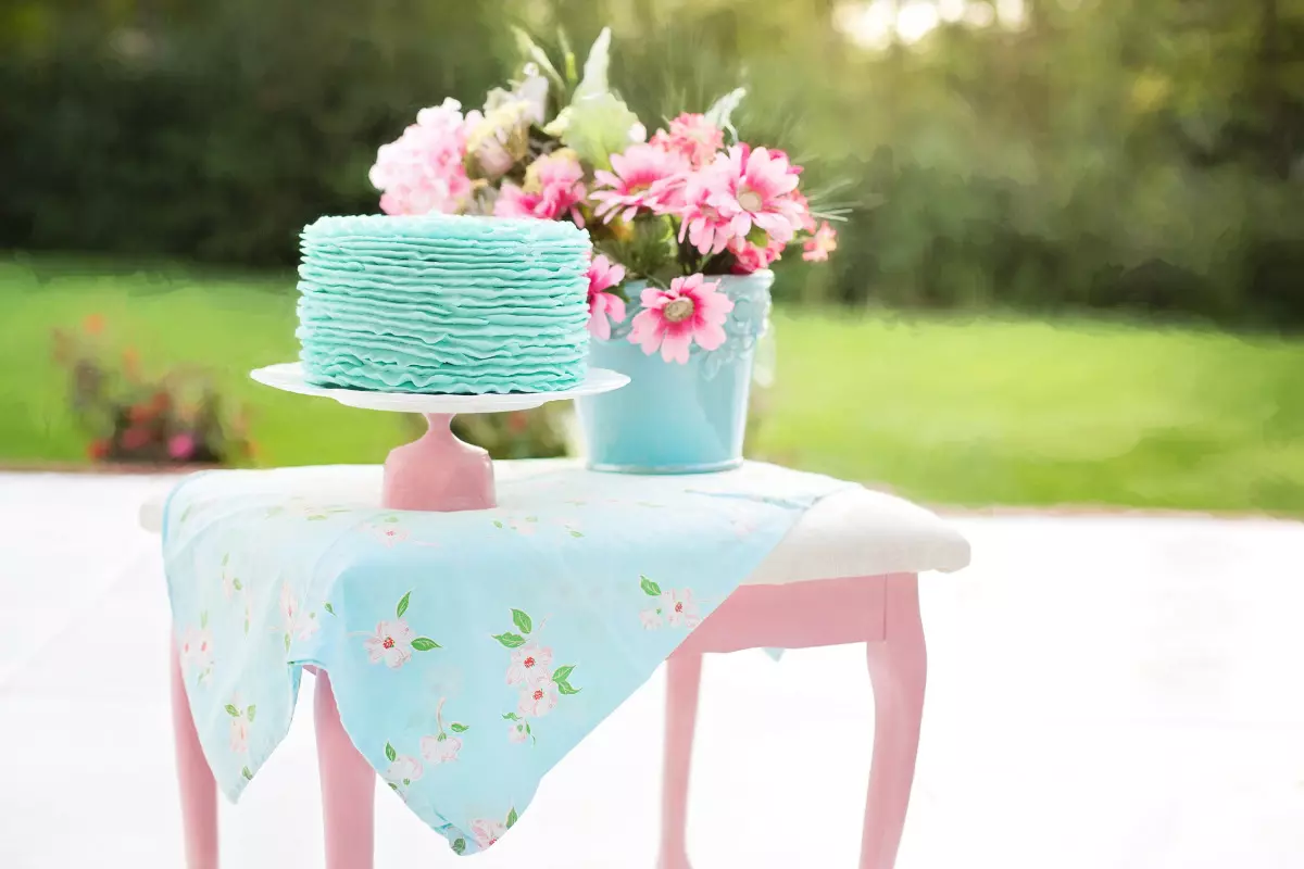 Como fazer uma decoração de aniversário simples: confira dicas! mesa rosa com bolo e flores. Imagem ilustrativa para texto decoração de aniversário simples.