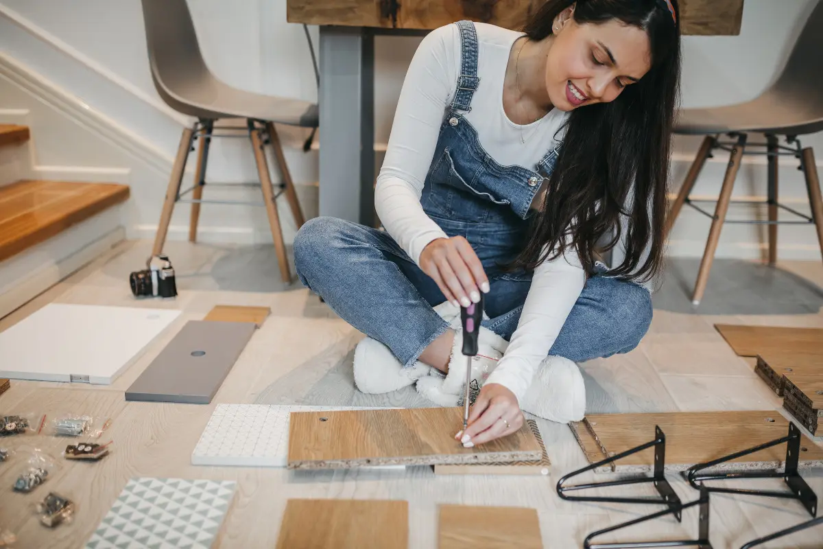 Bricolagem: entenda o conceito e confira ideias para aplicar em casa Mulher fazendo bricolagem com peças de madeira.